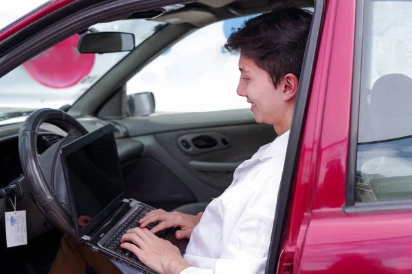 Yakışıklı delikanlı mekanik motor işlevleri kontrol etmek için cep telefonu uygulama sonuçlarını kontrol etmek için bir bilgisayar kullanın