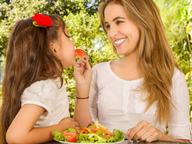 Güzel genç anne ve kızı sağlıklı bir başlatmak yeme eğleniyor