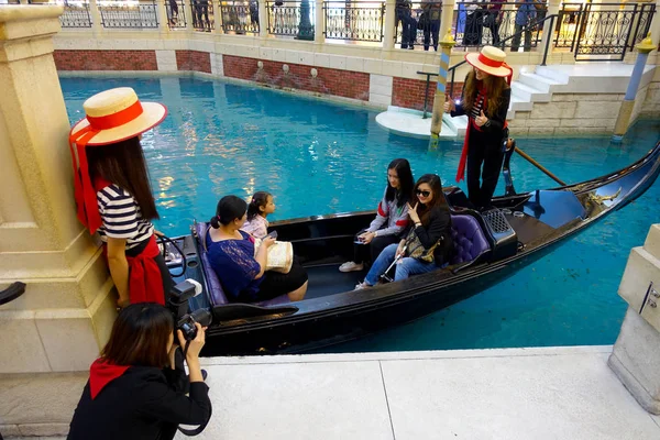 MACAU, CHINA- 11 DE MAYO DE 2017: Un pueblo no identificado teniendo un viaje en una góndola veneciana dentro de un hermoso hotel de lujo el Venetian Resort Hotel and Casino — Foto de Stock