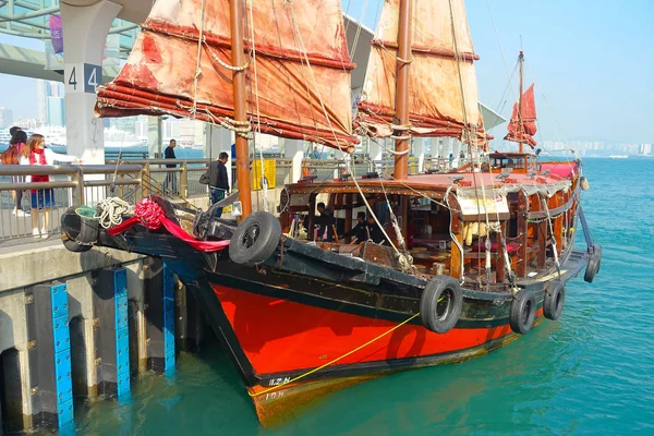 HONG KONG, CHINA - 26 DE ENERO DE 2017: Velero turístico en el puerto, vista panorámica del tradicional velero chino de madera con velas rojas. Rascacielos — Foto de Stock