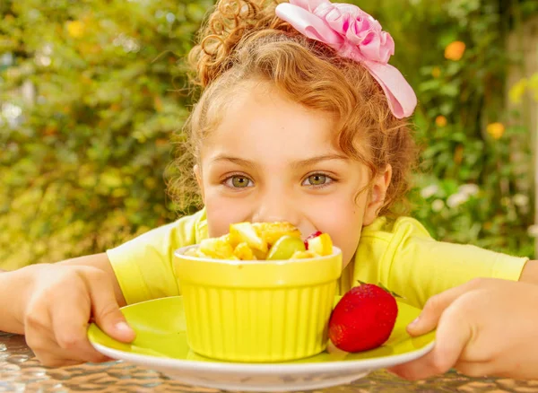 Bir bahçe arka planda sağlıklı meyve salatası yemek hazırlama sarı bir tişört giyen güzel bir genç kızın yakın çekim — Stok fotoğraf