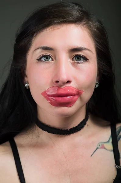 Mujer hermosa chica natural con una máscara de labio rosa, tratamientos de spa. Cosmetología en un fondo oscuro —  Fotos de Stock