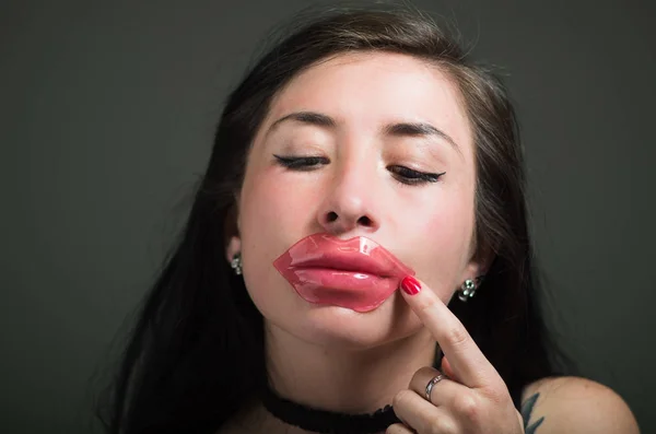 Beautiful natural girl woman aplying a lips pink mask, spa treatments. Cosmetology in a dark background — Stock Photo, Image