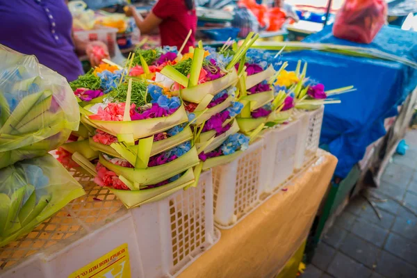Un mercado con una caja hecha de hojas, dentro de un arreglo de flores en una mesa, en la ciudad de Denpasar en Indonesia —  Fotos de Stock