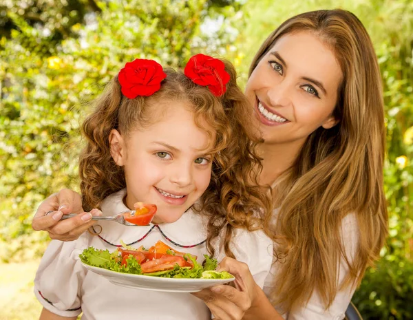 Beautiful young mother and daughter preparing to eat a healthy salad — Stock Photo, Image