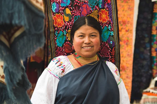 Otavalo, Ekvator - 17 Mayıs 2017: renkli kumaşlar arka planda kamera için poz and geleneksel giyim ve kolye, kimliği belirsiz İspanyol yerli kadın, kapat