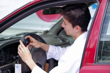 Yakışıklı delikanlı mekanik motor işlevleri kontrol etmek için cep telefonu uygulama kullanın