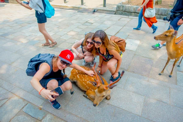 Nara, japan - 26. Juli 2017: Nahaufnahme von nicht identifizierten Frauen, die ein Selfie von einem wilden Hirsch in nara, Japan machen. nara ist ein bedeutendes touristisches ziel in japan - ehemalige hauptstadt und heute unesco-welt — Stockfoto