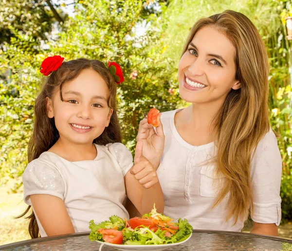 Güzel genç anne ve kızı sağlıklı bir salata yemeye hazırlanıyor — Stok fotoğraf