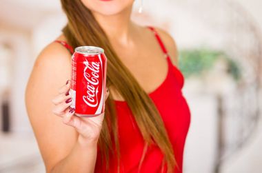 Quito, Ekvator - 06 Mayıs 2017: yerli bir giyim eşyası ve içinde ona bir kola bir orman arka planda işaret gülümseyen genç kadın