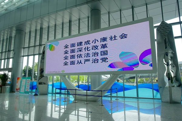 SHENZHEN, CHINA- 11 DE MAYO DE 2017: Zona de embarque con un escultural junto a la pantalla informativa dentro del ferry terminal que proporciona información previa de la salida del TurboJet que proporciona — Foto de Stock