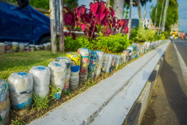 BALI, INDONESIA - 08 DE MARZO DE 2017: Una botella de agua de plástico en el parque al revés en fila, reciclado para adornar parques y avenidas, el concepto de protección ambiental en Denpasar Indonesia — Foto de Stock