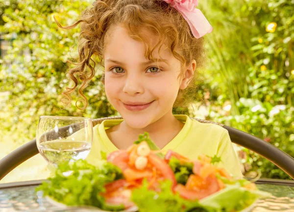 Mooi jong meisje, met een geel t-shirt voorbereiden om te eten een gezonde salade en drankje, in een tuin achtergrond — Stockfoto