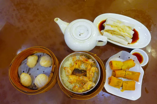 Ahşap bir masa, üstten görünüm üzerinde çeşitli Çin gıda kümesi, köfte ve pirinç şehriye böreği, ünlü Çin mutfağı yemekleri. Çin restaurant konseptini, Asya tarzı Ziyafet Hong Kong