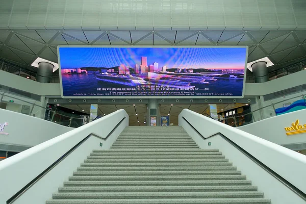 SHENZHEN, CHINA- MAY 11, 2017: Boarding area with a really big informative screen inside of the terminal ferry that provide information previous departure of the TurboJet that provides services — Stock Photo, Image