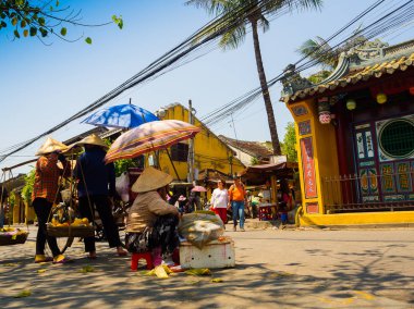 Hoian, Vietnam, Eylül, 04 2017: yürüyüş kimliği belirsiz bir kadın ve bir şemsiye onların elinde hangins omuz yemeklerine yakınındaki tapınağın hoian, Vietnam, holding ve bazı kadınlar