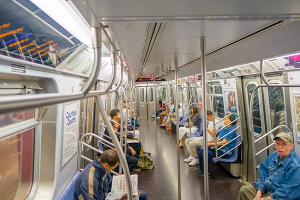 NOVA IORQUE, EUA - NOVEMBRO 22, 2016: Pessoas não identificadas sentadas dentro do metrô transporte público, metrô de Times Square subterrâneo em Nova York EUA — Fotografia de Stock