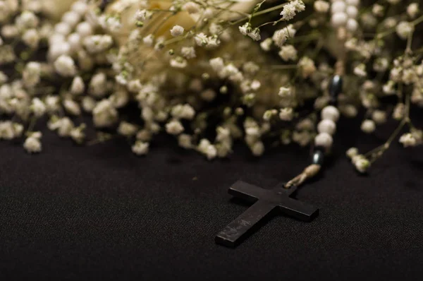 Закрываем бороду черным крестом с размытыми белыми мелкими цветками на черном фоне — стоковое фото