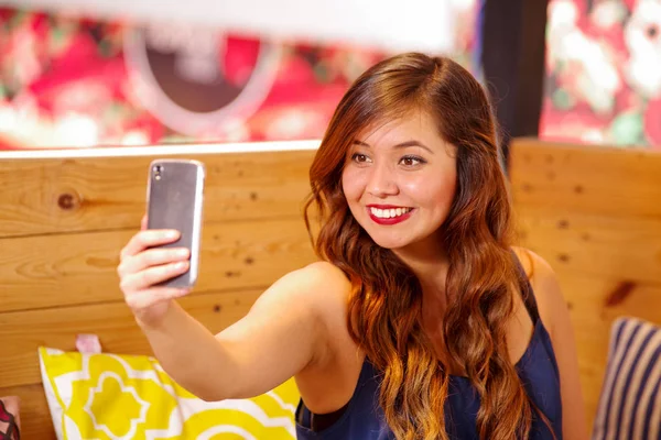 Sonriendo hermosa mujer pasar tiempo en un bar, es tomar un selfie a sí misma — Foto de Stock