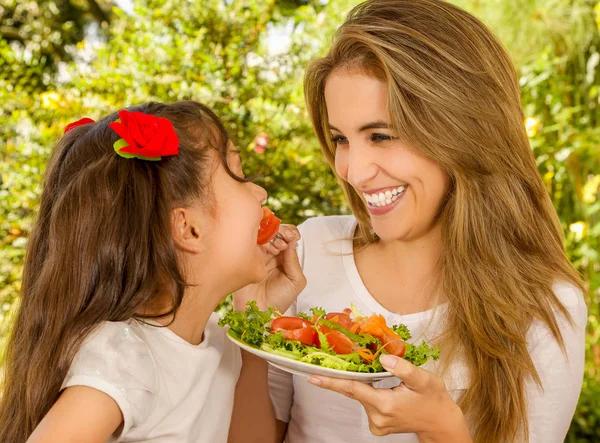 Güzel genç anne ve kızı sağlıklı bir başlatmak yeme eğleniyor — Stok fotoğraf