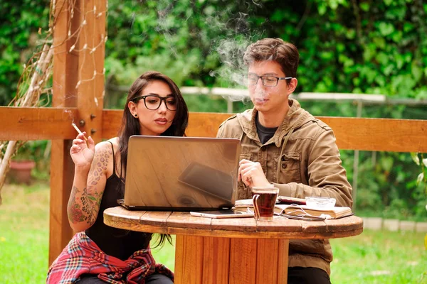 Hipster par rökning och arbetar på veranda med trähus, romantiska ögonblick, sommaren avkopplande tillsammans koncept, i en bakgård bakgrund — Stockfoto