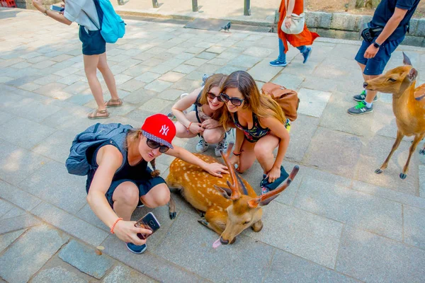 Nara, Japán - 2017. július 26.: Közelről az azonosítatlan nő vesz egy selfie, egy vadon élő szarvasok, Nara, Japán. Nara egy olyan jelentős turisztikai célpont Japánban - egykori fő város, és jelenleg Unesco világ — Stock Fotó
