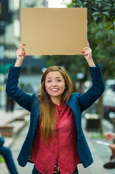 Jonge vrouw het dragen van casual kleding permanent buiten bedrijf in kartonnen poster, protesteren concept — Stockfoto