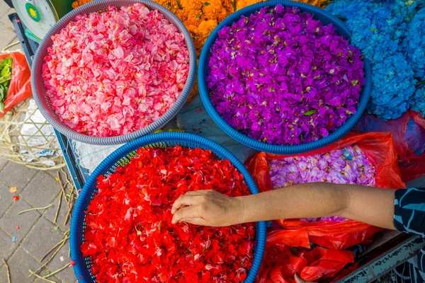 BALI, INDONESIA - MARCH 08, 2017: Outdoor Bali flower market. Flowers are used daily by Balinese Hindus as symbolic offerings at temples, inside of colorful baskets — Stock Photo, Image