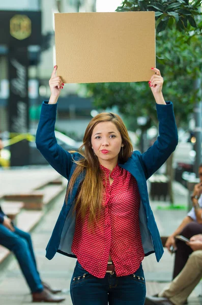 Jonge vrouw het dragen van casual kleding permanent buiten bedrijf in kartonnen poster, protesteren concept — Stockfoto