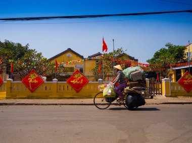 Hoian, Vietnam, Eylül, 04 2017: kağıt, Hoi bir antik kenti, Unesco Dünya Mirası sokak görünümü'nde eski evleri ve renkli lanters ile bisikleti kimliği belirsiz bir kadın yaptı. Hoi bir biridir