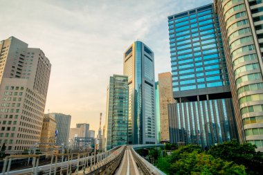 Tokyo, Japonya Haziran 28-2017: mavi açık güneşli gökyüzü altında Odaiba, Minato, Tokyo Yurikamome satırının yükseltilmiş demiryolu seyahat eden bir tren toplayan