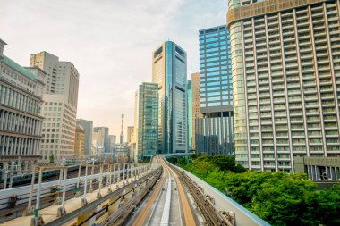 Tokyo, Japonya Haziran 28-2017: mavi açık güneşli gökyüzü altında Odaiba, Minato, Tokyo Yurikamome satırının yükseltilmiş demiryolu seyahat eden bir tren toplayan