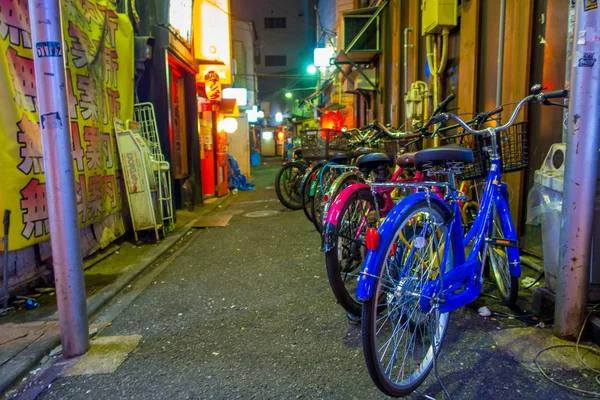 多彩的自行车在排在户外的美丽著名歌舞伎町的红灯区，周围的高楼大厦和广告，设在日本东京 — 图库照片