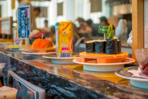 Tokyo, Japan -28 Jun 2017: närbild av blandade dominera mat över en tabell inuti en kaitenzushi conveyor belt sushirestaurang i Tokyo — Stockfoto