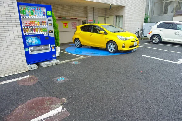 TOKIO, JAPÓN -28 JUN 2017: Coche aparcado cerca de la máquina de monedas de jugo y un medidor de máquina expendedora de aparcamiento para uso de las personas en la ciudad de Tokio — Foto de Stock