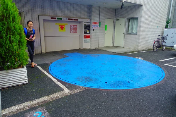 TOKYO, JAPÓN -28 JUN 2017: Mujer no identificada esperando cerca del medidor de máquina expendedora de estacionamiento para uso de personas en la ciudad de Tokio — Foto de Stock