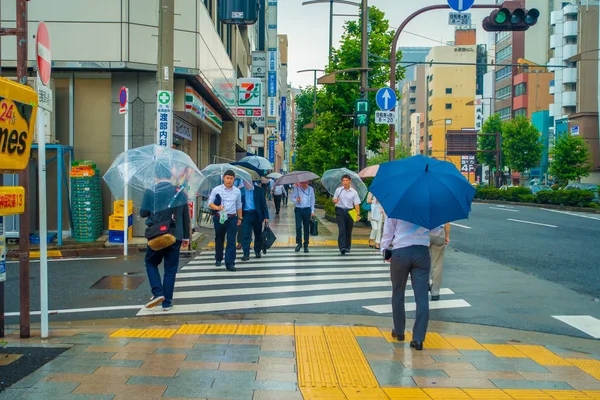 東京都 6 月 28-2017: 地区に位置する東京の神保町の通りの横断歩道上の傘の下で正体不明の人 — ストック写真