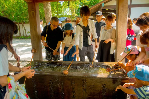 TOKIO, JAPÓN 28 DE JUNIO - 2017: Personas no identificadas en el Templo Kotokuin en Kamakura, Japón, lavabo y bañadores para lavarse las manos y la boca antes de entrar en el santuario — Foto de Stock