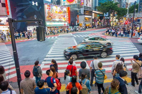 Tokyo, Japonsko června 28-2017: neznámí lidé čekají zelenou pro křižovatku Shibuya, zatímco některá auta přes ulici v Tokiu, Japonsko. Přechod pro chodce slavné vyškrábat se používá — Stock fotografie