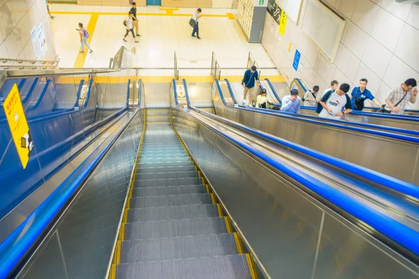 TOKYO, JAPAN JUNE 28 - 2017: Unidentified people walking downstairs and upstairs in electric stairs inside of train station to take the train. Its very convenient way for visitors to travel around — Stock Photo, Image