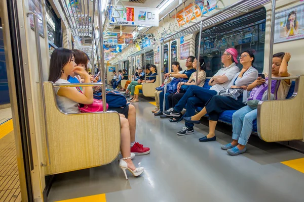Токио, Япония - 2 января 2016 г. Люди сидят в поезде Яманоте в Токио, Япония. Железнодорожная система Японии имеет высокую репутацию пунктуальности и безопасности . — стоковое фото