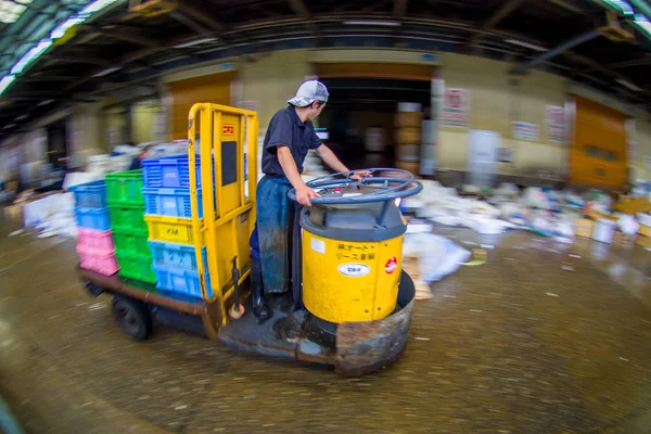 Tokyo, Japan juni 28-2017: onbekende man een machine erg snel binnen in een gebouw rijden op de Tsukiji Vismarkt is de grootste vis en zeevruchten groothandelsmarkt in de wereld, in Tokio. Met een — Stockfoto