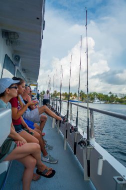 Fort Lauderdale, Amerika Birleşik Devletleri - 11 Temmuz 2017: Fort Lauderdale, Florida büyük tekneler balıkçılık çubuklar önünde otururken kimliği belirsiz kişi