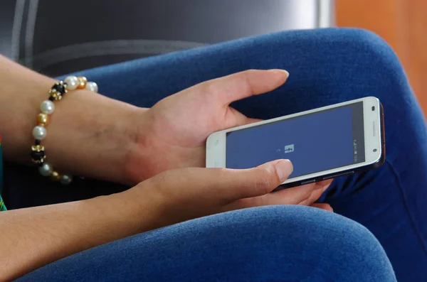 Quito, Équateur - 09 mai 2017 : Femme avec téléphone portable moderne dans les mains connexion écran facebook icônes sur Apple iPhone. Site de réseautage social le plus grand et le plus populaire au monde — Photo