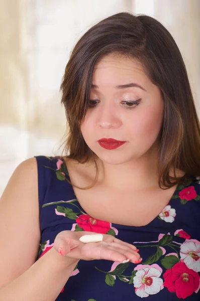 Primer plano de una mujer sorprendida sosteniendo en su mano una tableta o supositorio vaginal de gelatina suave, tratamiento de enfermedades de los órganos reproductivos de las mujeres y prevención de la salud de las mujeres — Foto de Stock