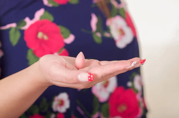 Zbliżenie dłoni Kobieta, trzymając w jej otwartej dłoni, miękkiej żelatyny pochwy tabletu lub czopek, leczenie chorób narządów rozrodczych kobiety i profilaktyki zdrowia kobiet — Zdjęcie stockowe