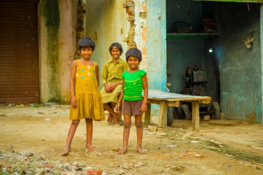 Jaipur, Hindistan - 20 Eylül 2017: Portre çocukların, sarı bir kirli bluz ve yeşil tişört ve kahverengi pantolon giyen ve Hindistan Jaipur şehrinde sokakta sarhoş bir zemin üzerinde