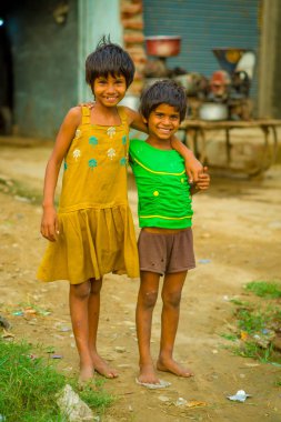 Jaipur, Hindistan - 20 Eylül 2017: Sarılma ve gülümseyen, sokakta sarhoş bir zemin üzerinde sarı bir kirli bluz ve yeşil tişört ve kahverengi pantolon giyen iki güzel kız portresi