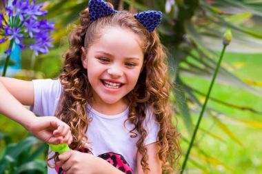 Mavi kulakları kaplan Aksesuar bulanık doğa arka planda onun Merkez over sabun köpüğü bir yaz niteliğine oynamaktan mutlu küçük kıvırcık gülümseyen kız giyiyor