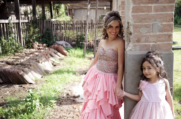 Beautiful woman and her cute little daughter looking at camera and smiling wearing a princess dress in outdoors — Stock Photo, Image